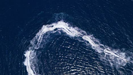 aerial view of two people riding jetskis in the ocean
