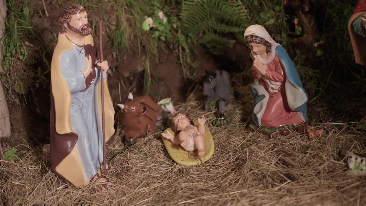 classic nativity scene with baby Jesus in a manger, Mary and Joseph in prayer, and barn animals in a natural setting