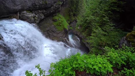 Waterfall-on-cliff-in-mountains-near-trees