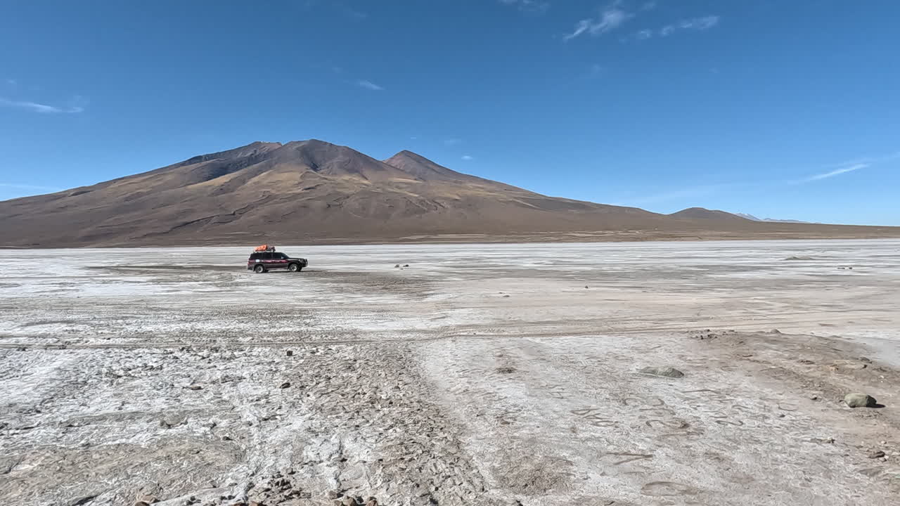 el coche off-road de aterrizaje atraviesa el salino seco y estéril de bolivia.