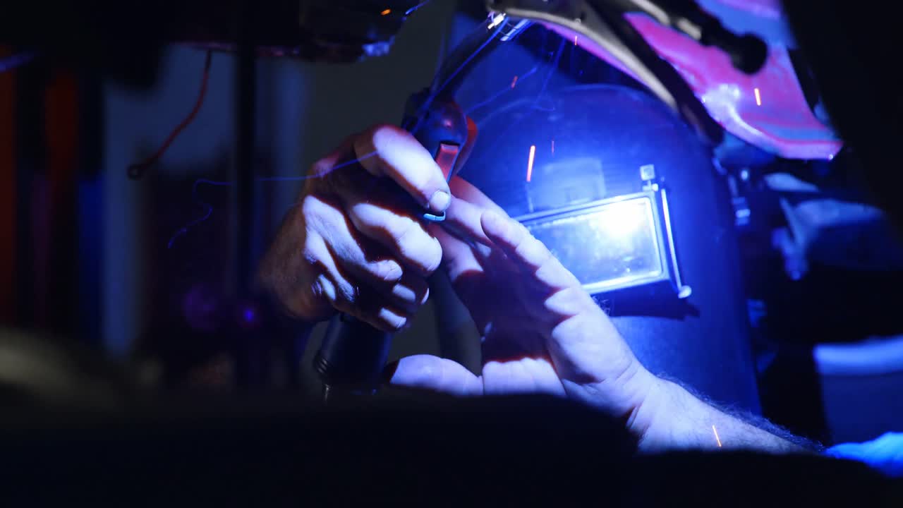 mecánico masculino usando una antorcha en llamas en el garaje 4k