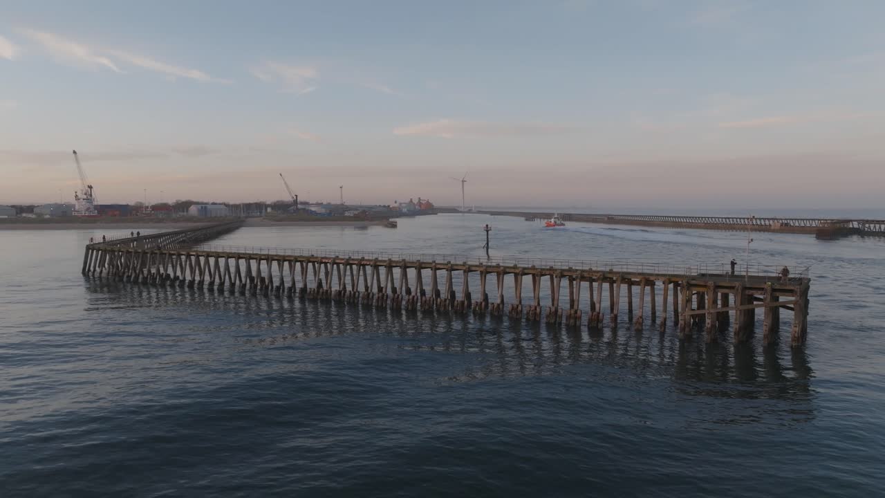Aerial view of the Blyth pier at sunset with vessel entering the harbour.