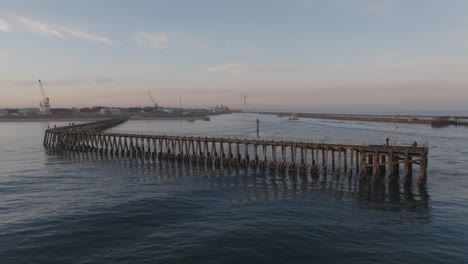 aerial view of the blyth pier at sunset with vessel entering the harbour.