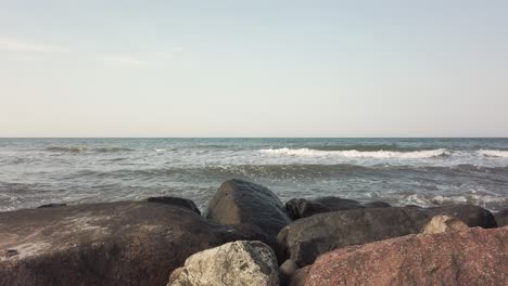 Pedestal-up-shot-rising-from-behind-rocks-to-reveal-wide-view-of-sea