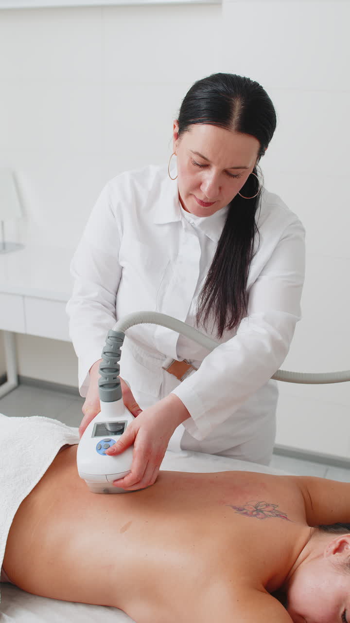 el médico hace a la mujer cavitación lpg masaje de rollo de vacío en la espalda cifras de corrección en la clínica de spa