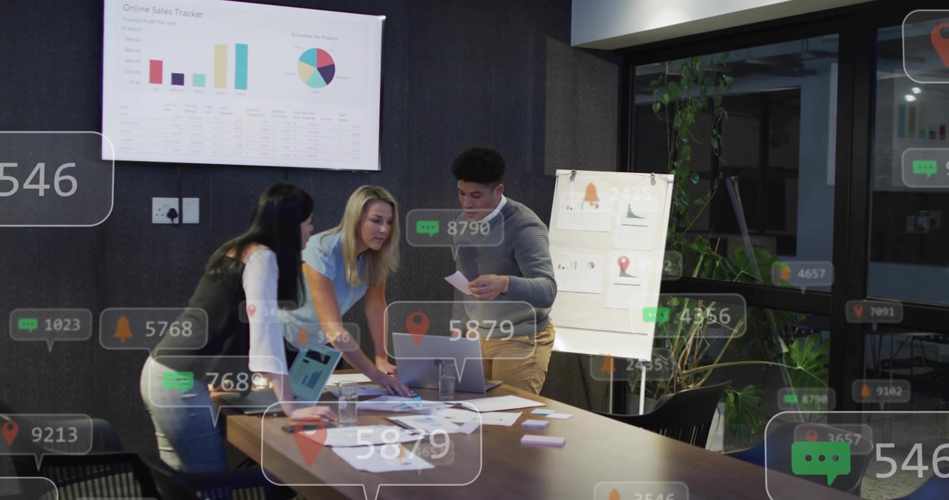 Equipo de negocios inclinado sobre una laptop y documentos, haciendo que las alertas floten sobre los gráficos, organizando datos