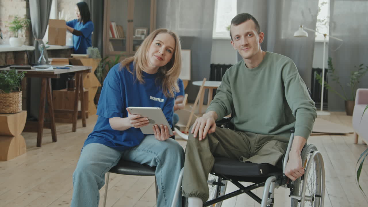 Volunteer Setting up Internet for Disabled Man on Tablet