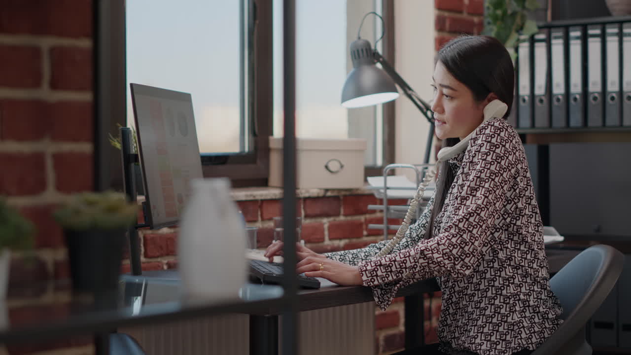 Business woman using landline phone to talk on phone call