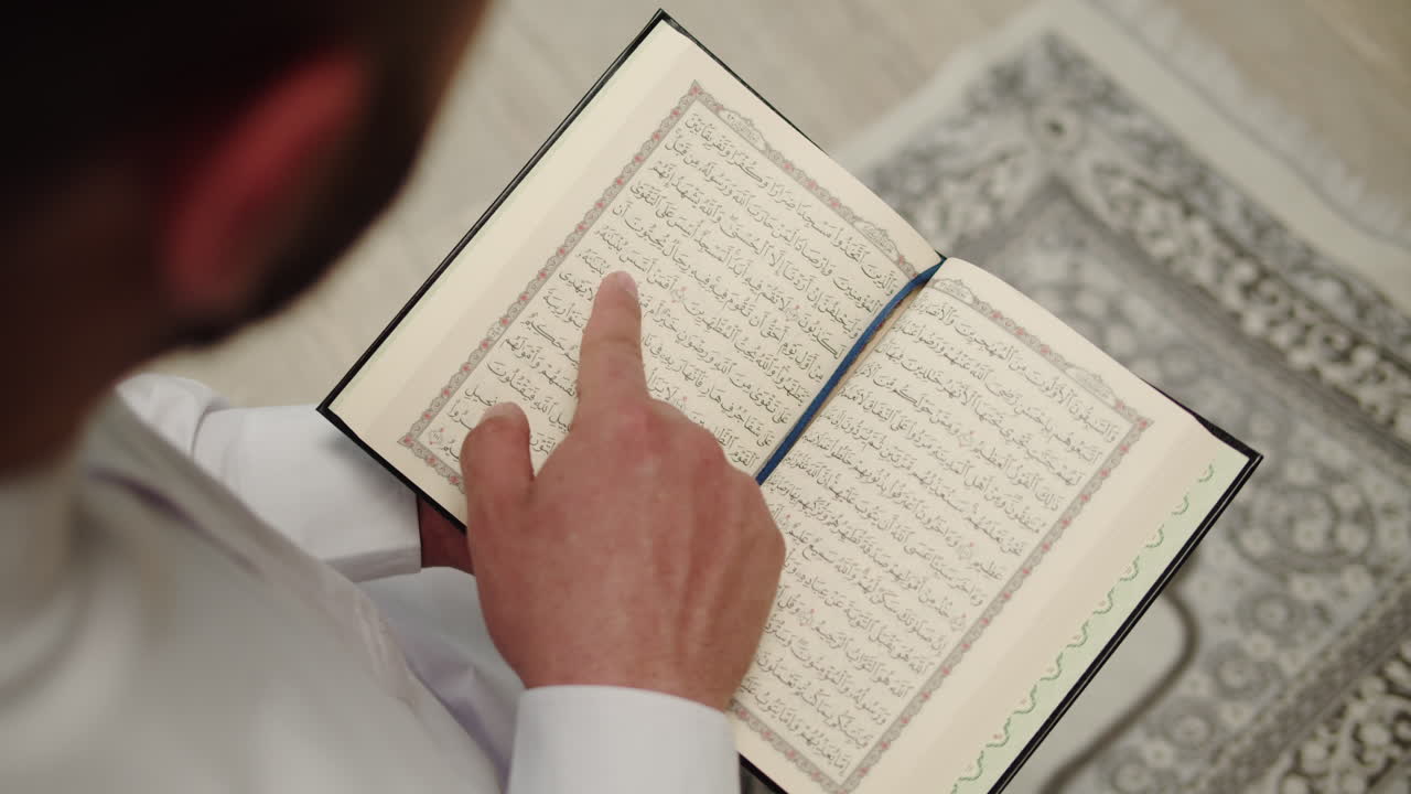 A Muslim person reading the Holy Quran and pointing at the text