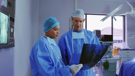 vista frontal de médicos multiétnicos discutiendo sobre el informe de rayos x en el hospital