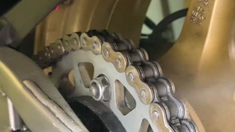 oiling a motorcycle chain in a workshop