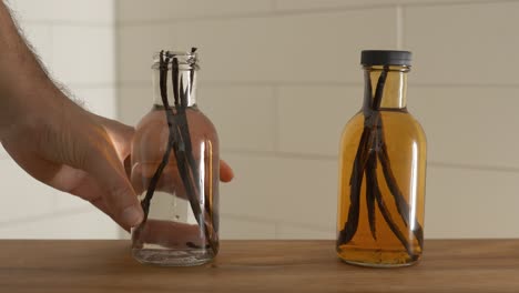 two bottle of vanilla beans with vodka, one fresh and one after months of fermenting