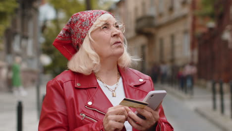 Senior woman using credit bank card smartphone while transferring money purchases online shopping