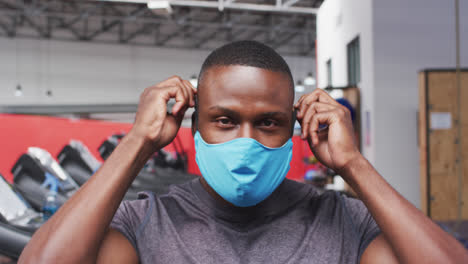 fit african american man wearing face mask in the gym