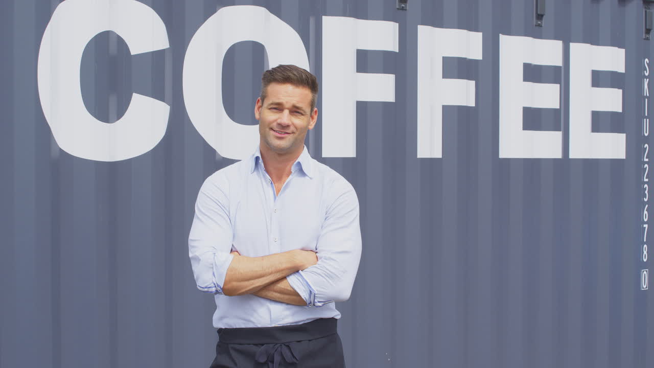 Portrait Of Male Owner Of Coffee Shop Or Distribution Business Standing By Shipping Container