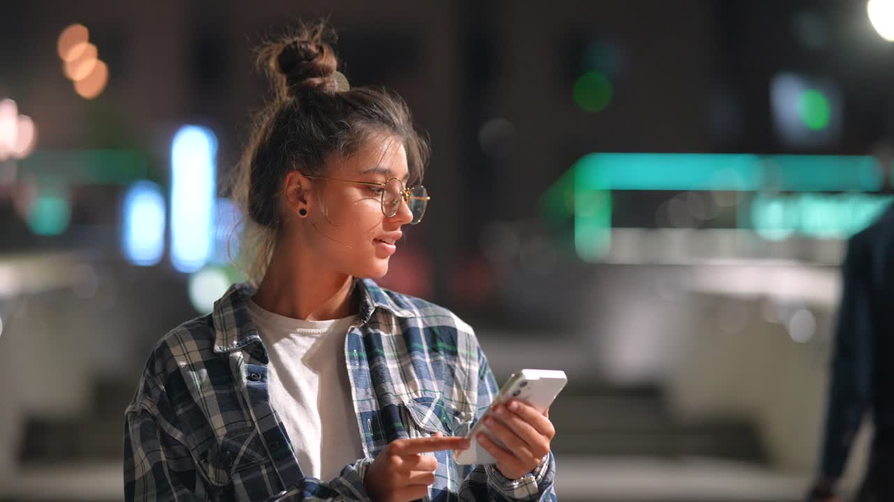 mujer joven usando teléfono inteligente por la noche