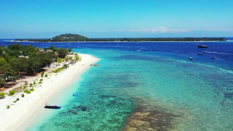 beautiful scenery of fiji island composed of green trees and white sand surrounded by bright blue ocean and sailing boat - aerial shot