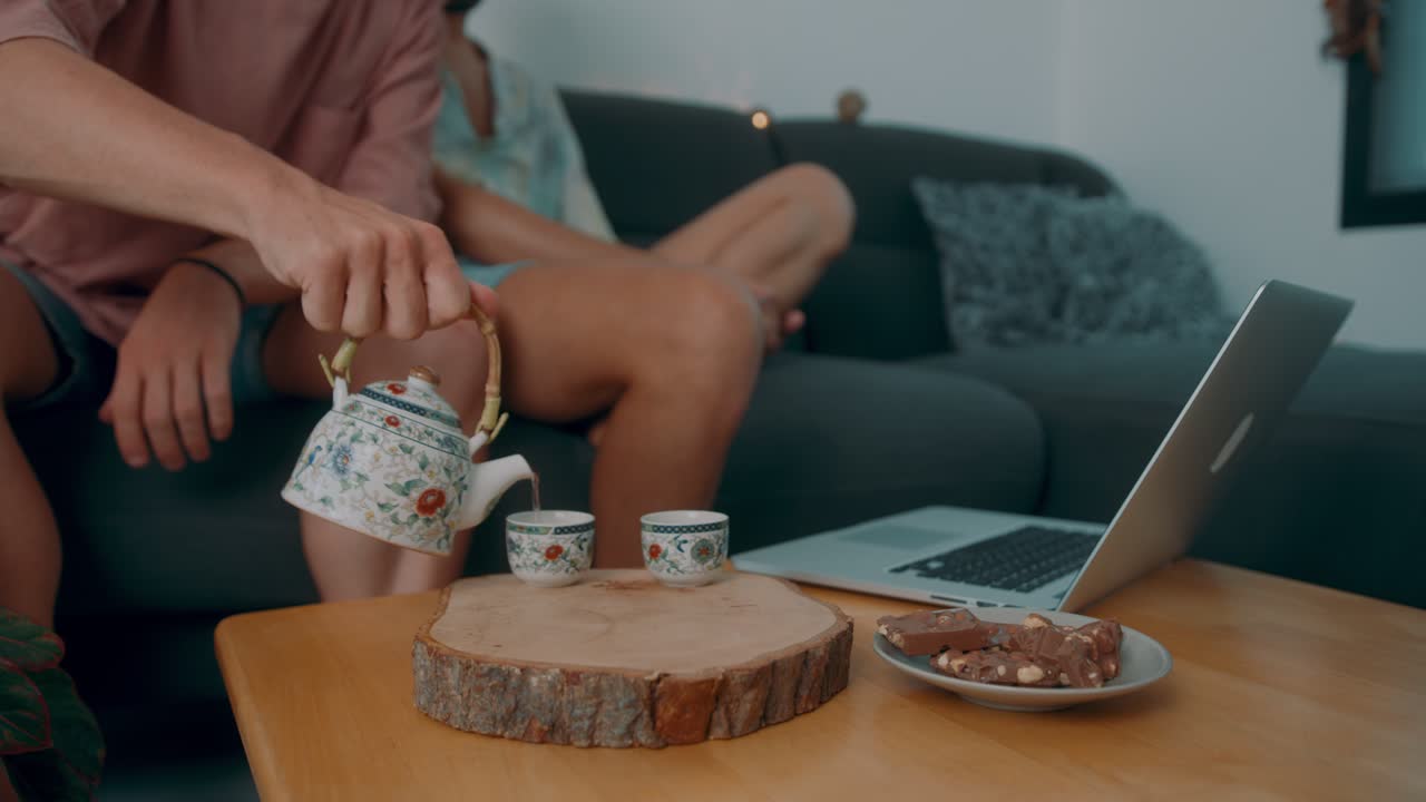 家でお茶とお菓子を楽しむ同性カップル