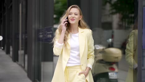 woman in yellow business outfit talking on phone