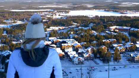 Chica-De-Esquí-Con-Vistas-A-La-Estación-De-Esquí-De-La-Ciudad-De-Levi,-Finlandia