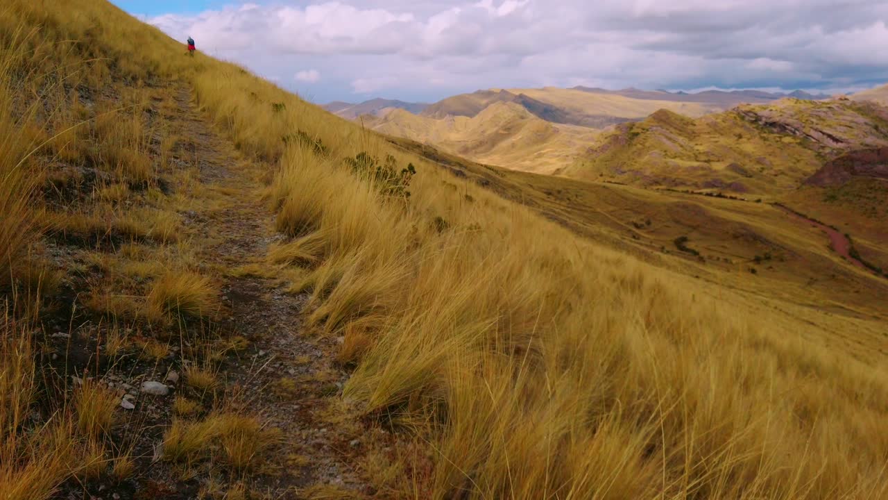 Off the beaten path in the Peruvian Andes. High altitude trails near city of Cusco, Peru, with gold vegetation, steep ridges and valleys. Huanacaure trek