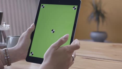 mujer usando una tableta con una pantalla verde
