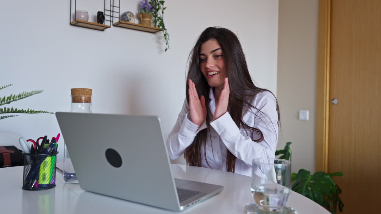 Giovane donna reagisce con gioia ed entusiasmo a buone notizie sul laptop