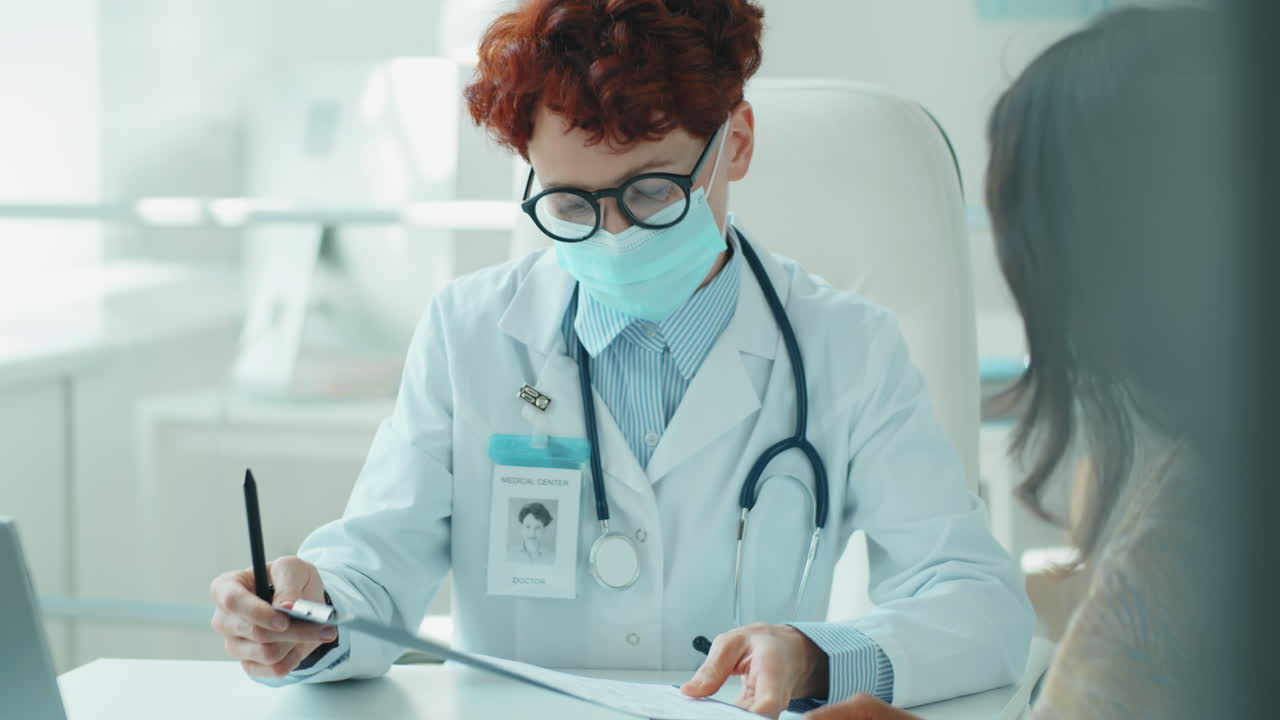 Female Doctor in Mask Giving Consultation to Patient