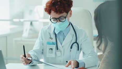 doctora con máscara dando consulta al paciente