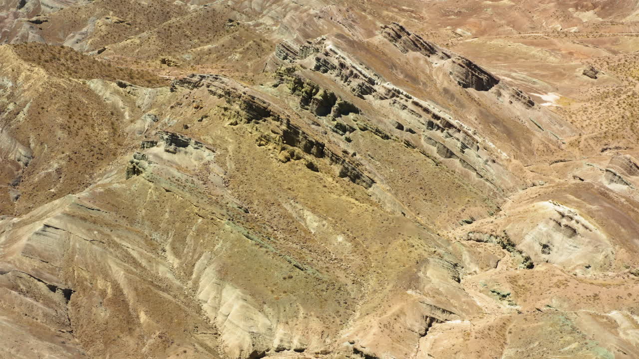 volando sobre las antiguas formaciones montañosas en capas en la cuenca del arco iris parte del desierto de mojave