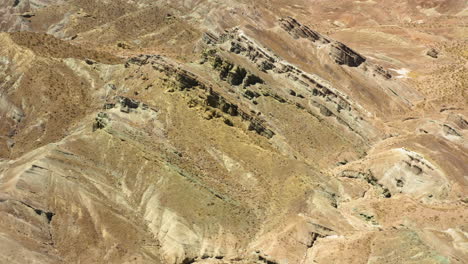 volando sobre las antiguas formaciones montañosas en capas en la cuenca del arco iris parte del desierto de mojave