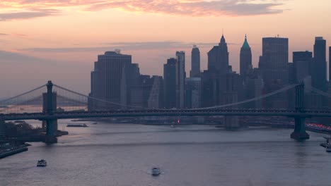 manhattan bridge and brooklyn bridge are viewed against the background of lower manhattan and financial district from williamsburg during twilight