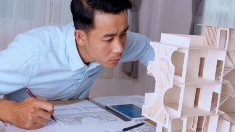 young architect working with house model