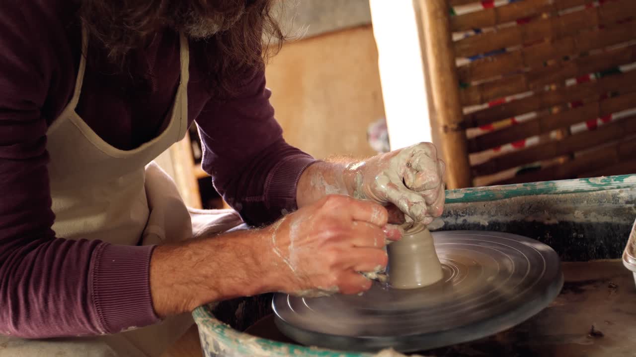 Mid section of potter making pot