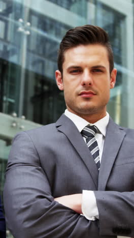 businesspeople standing with arms crossed in office building