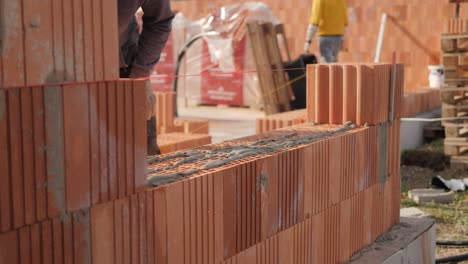 Pared-De-Albañil-En-Un-Sitio-De-Construcción,-El-Trabajador-Está-Poniendo-Mortero-En-Los-Ladrillos,-Constructor-De-Habilidades-Profesionales