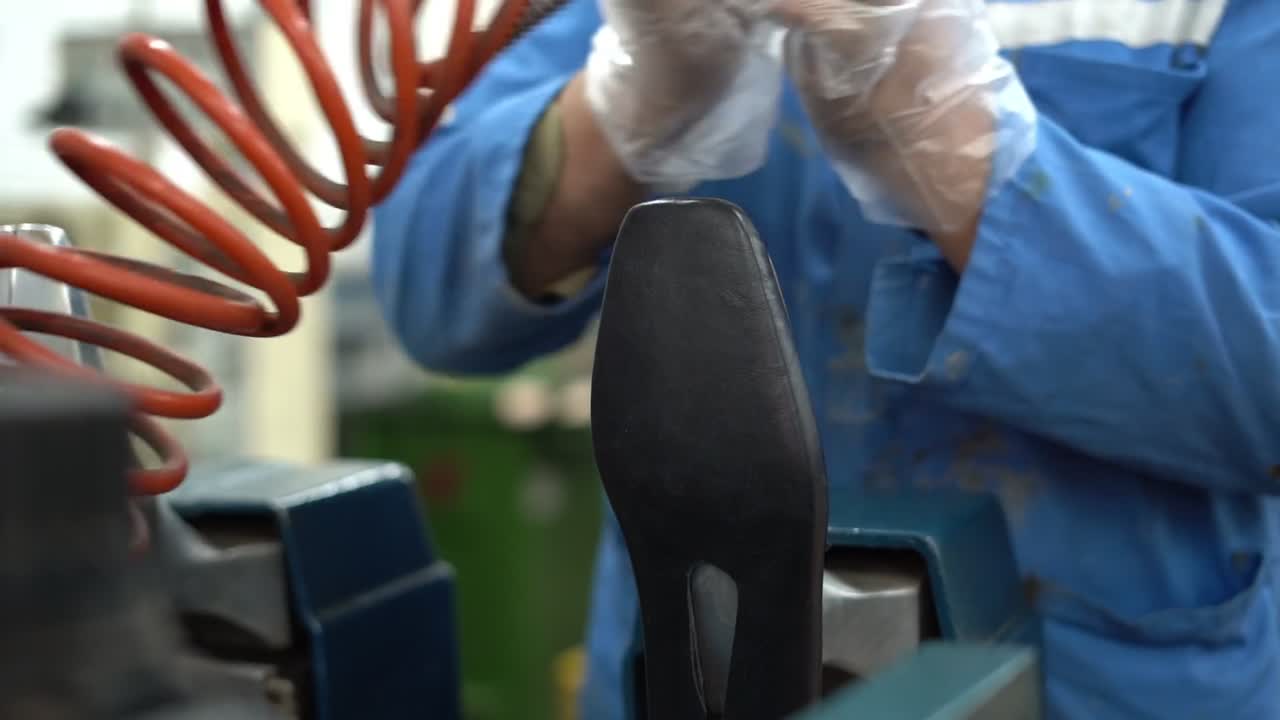 a craftsman handmade a shoe by a machine, close up shot, insert shot