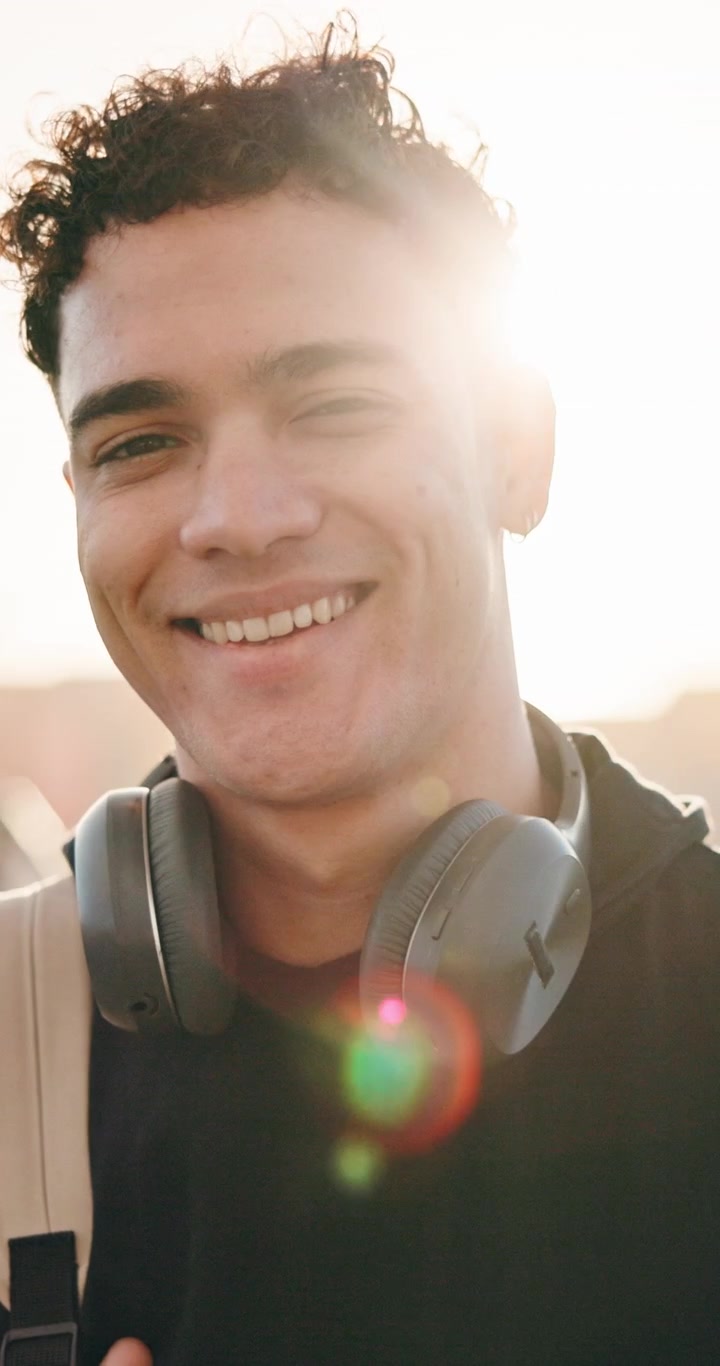 Ritratto di un Giovane Uomo Sorridente con Cuffie all'Aperto