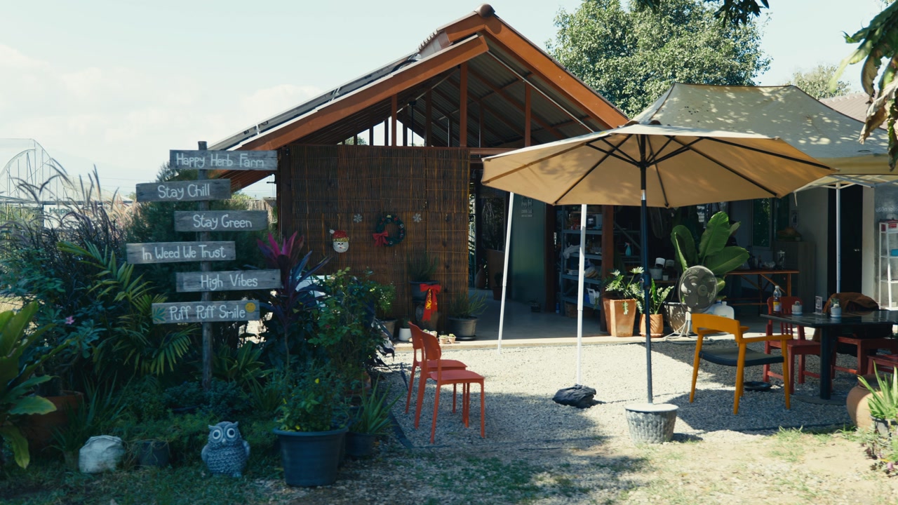 A Thai restaurant set in a beautiful garden in the countryside of Chiang Mai, Thailand, captured on a sunny day with lush greenery and a peaceful atmosphere.