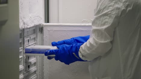 scientist examining blood samples in a laboratory freezer