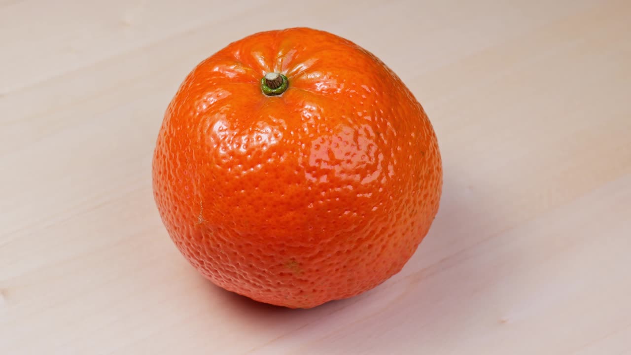 ripe tangerine spinning close-up slowmo