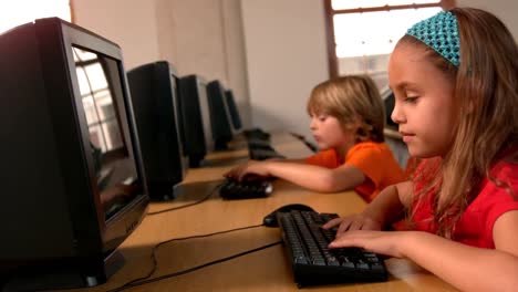 cute pupils working on computers in classroom