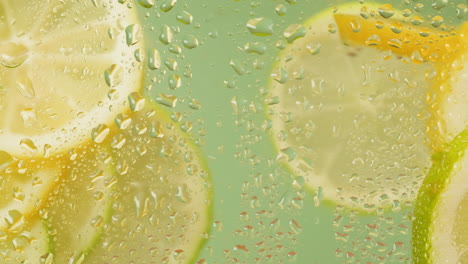 close-up of fresh lemon and lime slices in water
