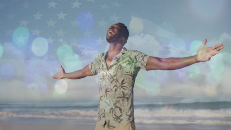 puntos de luz contra el hombre afroamericano con los brazos abiertos disfrutando en la playa