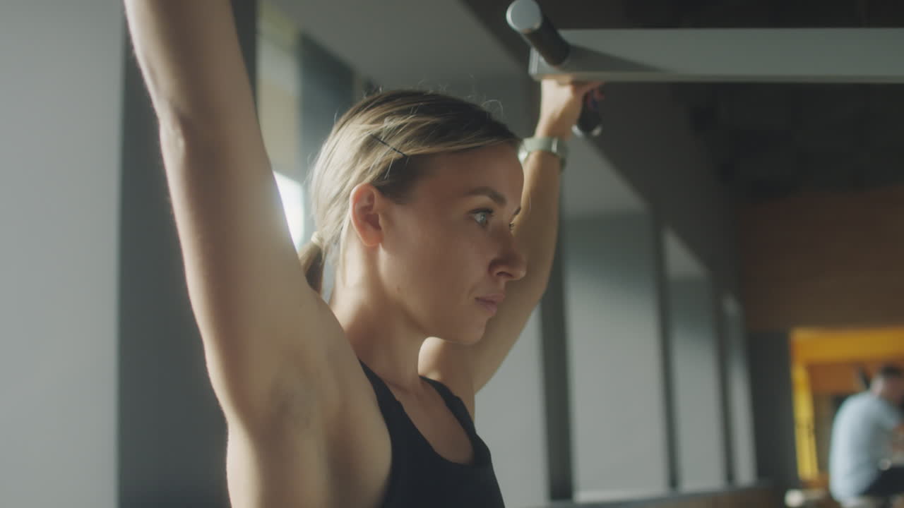 Woman Using Lat Pulldown Machine in Gym