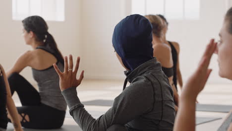 healthy yoga woman practicing half lord of fishes pose young muslim female wearing headscarf enjoying fitness lifestyle exercising in studio with group of multiracial women