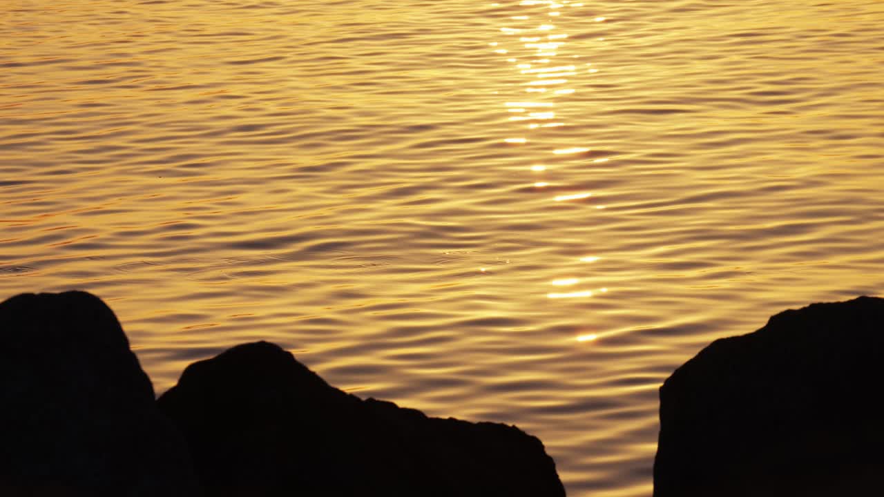 Golden Sunset over Water with Rocks