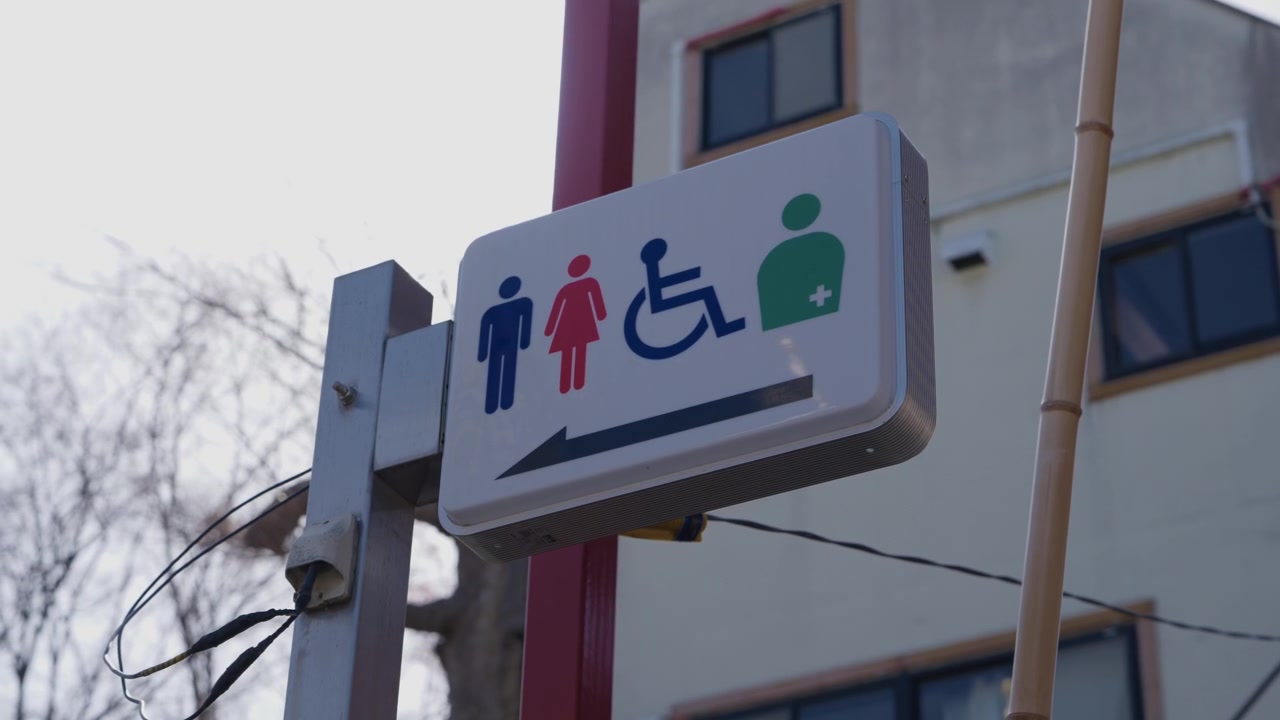Cartello del bagno con icone per uomini, donne, accessibile e per ostomizzati in Giappone.