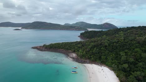 drone-view-over-Whitehaven-beach-in-the-Whitsundays-with-tourist-boats-in-the-foreground,-Queensland,-Australia