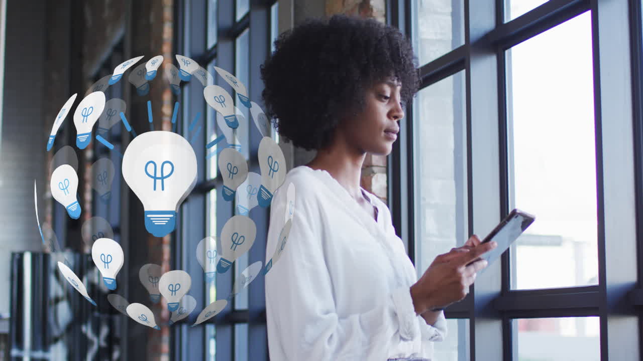 Animation of globe of light bulb icons over african american woman using tablet